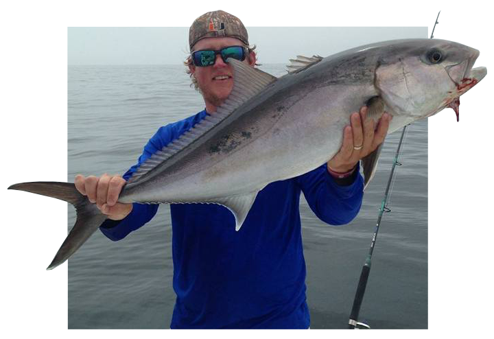 man with a cap and sunglasses holding a huge fish